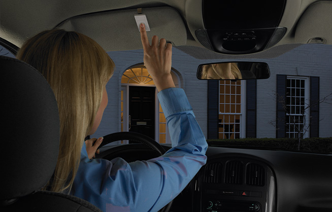 Woman reaching for Pico remote on car visor clip while pulling into her driveway