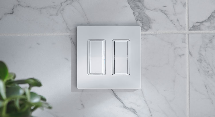 Diva Smart Dimmer and Claro Smart Accessory Switch on white kitchen tile wall.