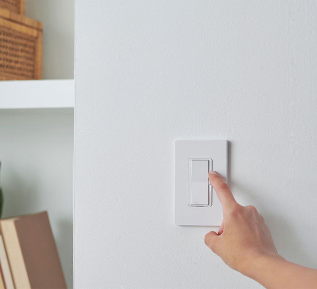 Woman dimming light using the Diva smart dimmer