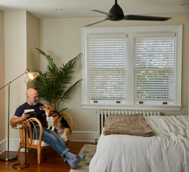 Man and dog sitting on chair with Pico smart remote for fan control