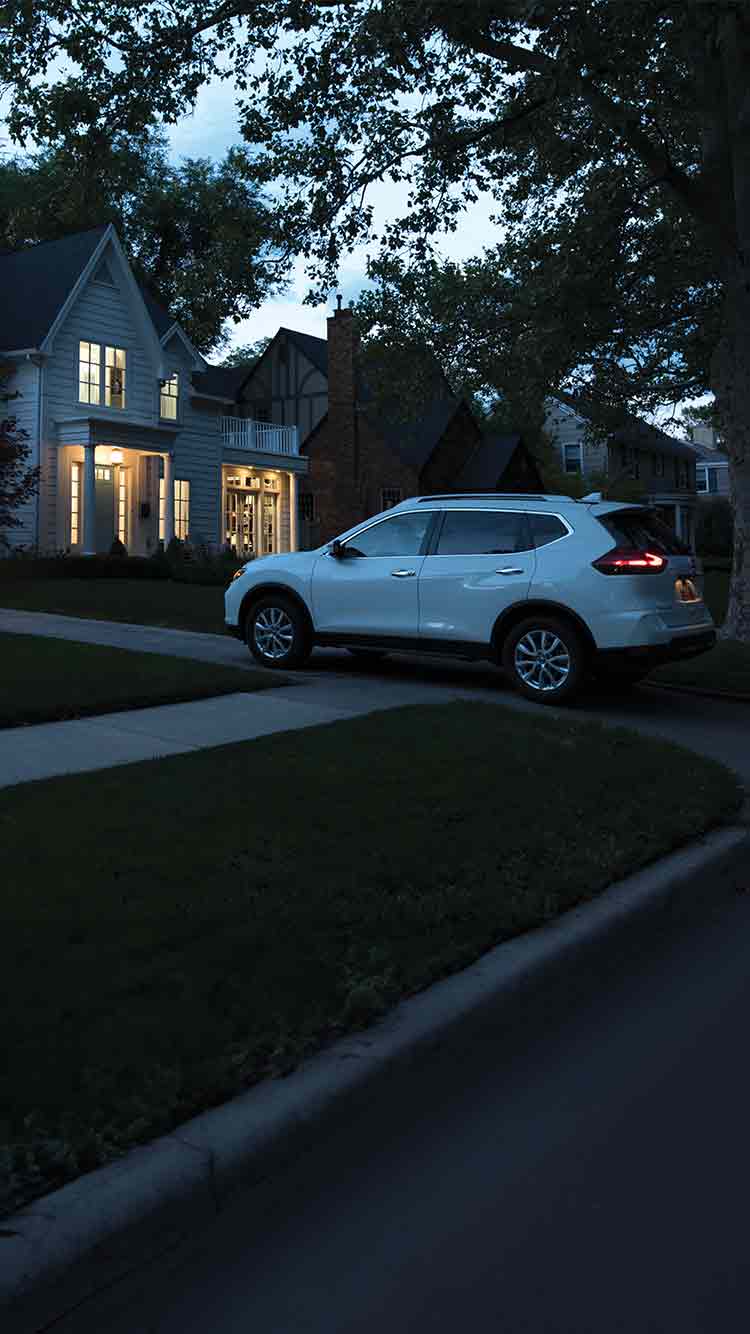 Family arriving home in car with smart lights on inside and outside