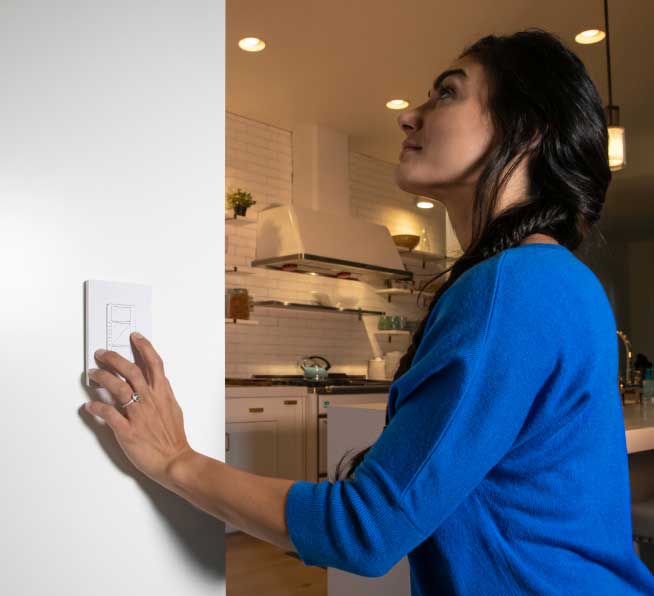 Woman dimming lights using Original smart dimmer on wall