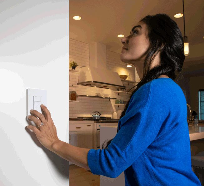 Woman dimming lights using Original smart dimmer on wall