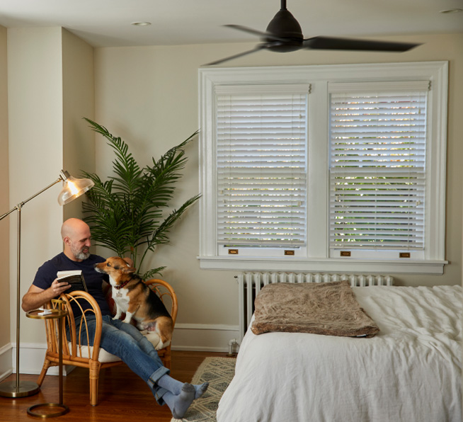 Man and dog sitting on chair with Pico smart remote for fan control