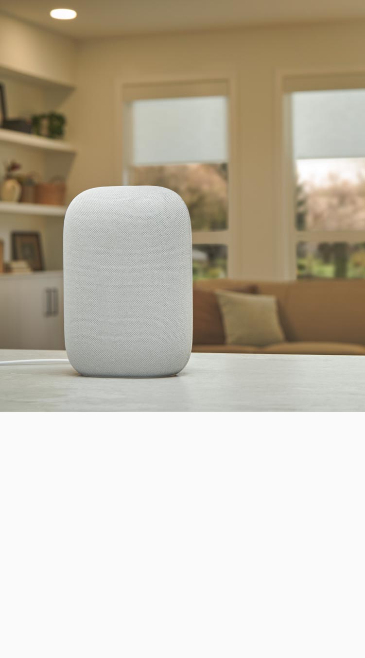 Illuminated Google smart speaker on countertopwith living room in the background