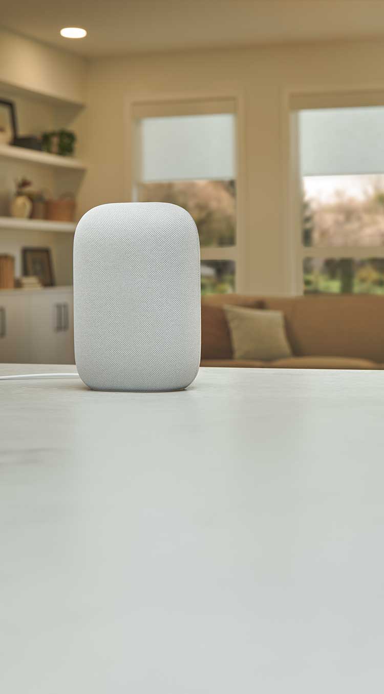 Illuminated Google smart speaker on countertopwith living room in the background