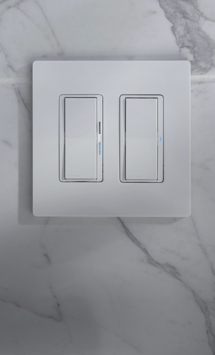 Diva smart dimmer and Claro smart switch on white kitchen tile wall