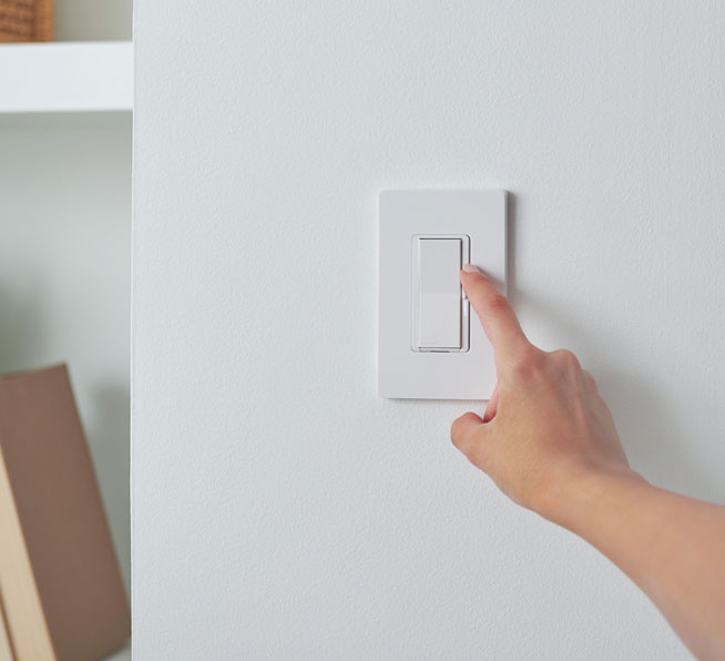 Woman dimming light using the Diva smart dimmer