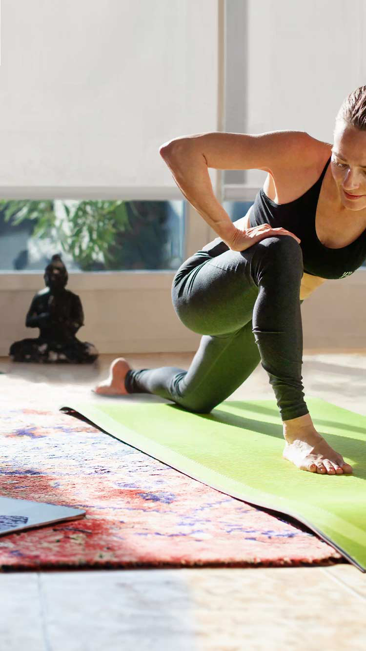 Woman practicing yoga with roller shades providing privacy