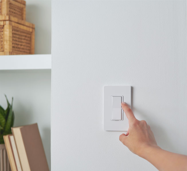 Woman dimming light using the Diva smart dimmer