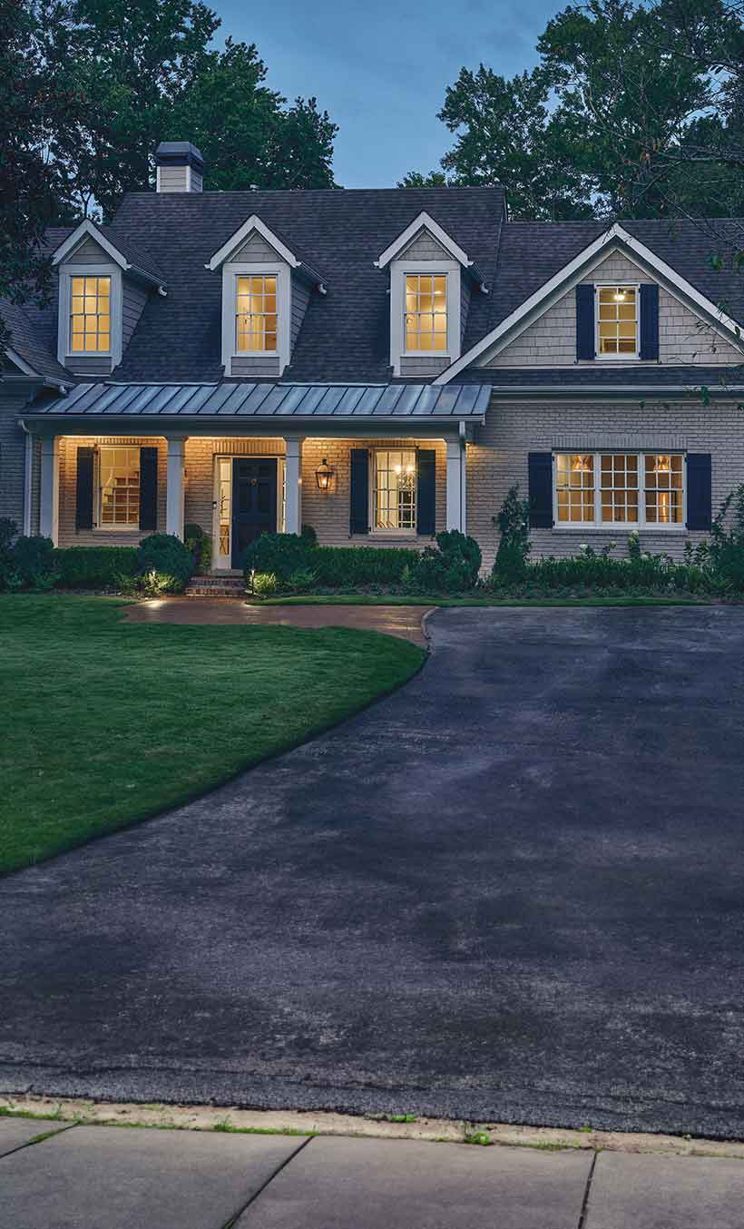 Exterior of home at dusk with lights on inside