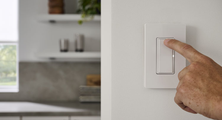 Man oressing Slaro smart switch mounted on kitchen wall.