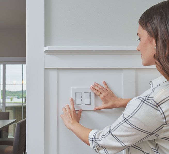 Woman placing a wallplate on wall-mounted Pico remote.